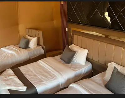 two beds in a room with white sheets and pillows at The bubble camp in Wadi Rum