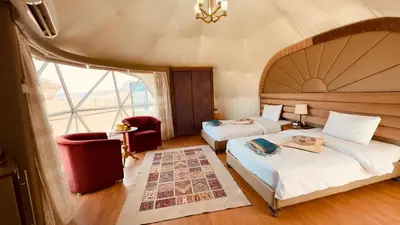 a bedroom with two beds and a large window at The bubble camp in Wadi Rum