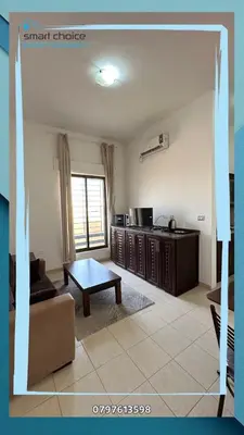 a living room with a couch and a table at استوديو مفروش بالقرب من جامعة الشرق الأوسط in Amman