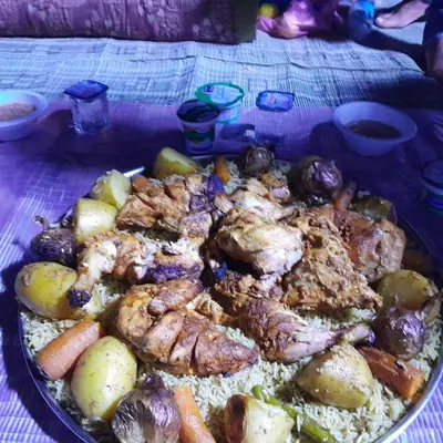 a plate of food with meat and vegetables on a table at - Trekking from Dana to Petra in Dana