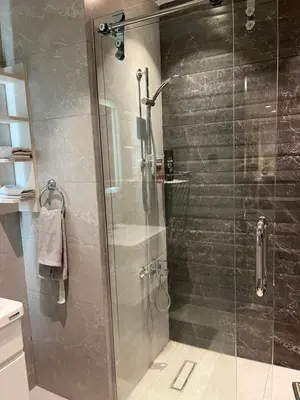a shower with a glass door in a bathroom at DAMAC Luxury new 1 bedroom apartment in Amman