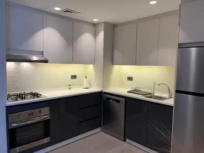 a kitchen with black cabinets and stainless steel appliances at DAMAC Luxury new 1 bedroom apartment in Amman