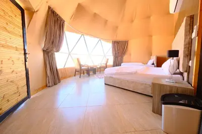 a bedroom with a bed and a large window at Wadi Rum Desert Bedouins in Wadi Rum