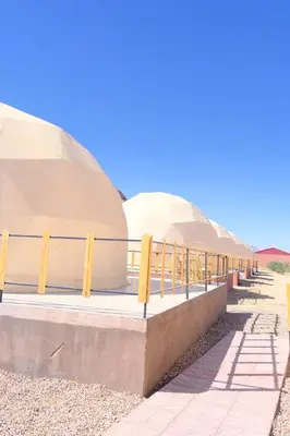 two domes in the desert with a fence around them at Wadi Rum Desert Bedouins in Wadi Rum