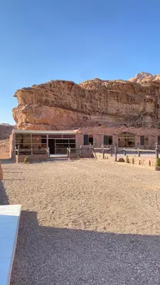 a building in the middle of a desert with a cliff at Wadi Rum Desert Bedouins in Wadi Rum