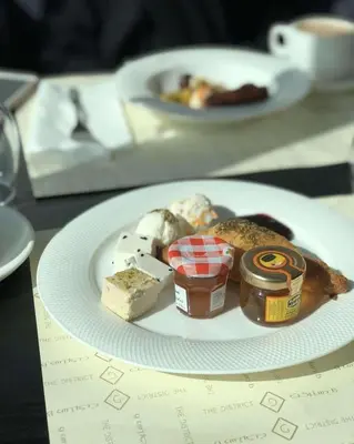 a plate of food with cheese and jam and bread at Angelina Luxury Camp in Wadi Rum