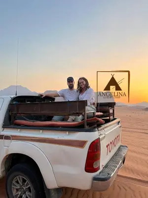 a man and a woman sitting in the back of a truck at Angelina Luxury Camp in Wadi Rum