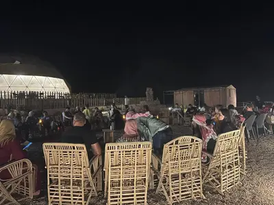 a group of people sitting in chairs at night at SARAB Luxury Camp in Wadi Rum