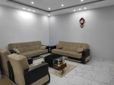 a living room with two couches and a clock on the wall at Oskar Appartment in Wadi Musa