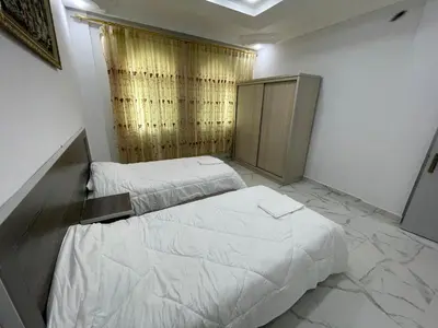 a bedroom with two beds and a cabinet in it at Oskar Appartment in Wadi Musa