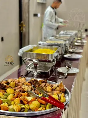a buffet line of food with a chef in the background at Najd Luxury Camp in Wadi Rum