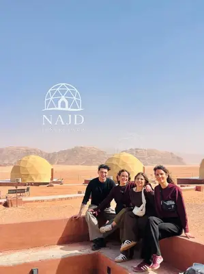 a group of people posing for a picture in the desert at Najd Luxury Camp in Wadi Rum