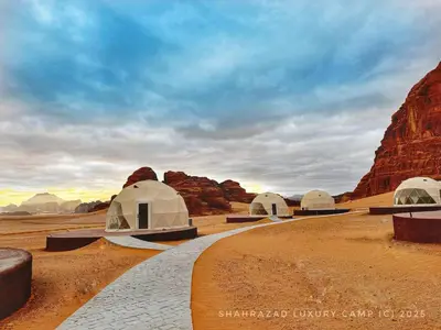 a group of domes in the desert with mountains at Omsiat Shahrazad Luxury Camp in Wadi Rum