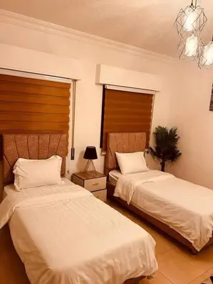 a bedroom with two beds and a chandelier at Lovely 3 bedrooms rental unit in Aqaba
