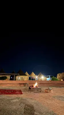 a fire is burning in the dirt at night at Wadi Rum Beyond nature in Wadi Rum
