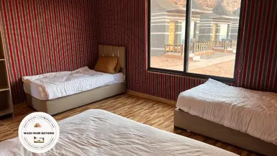 a bedroom with two beds and a window at Wadi Rum Beyond nature in Wadi Rum