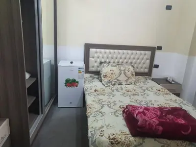 a small bedroom with a bed and a refrigerator at Alfares Hotel in At-Tafilah