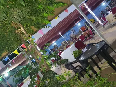 a group of people sitting at a table in a restaurant at Alfares Hotel in At-Tafilah