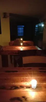 a lit candle sitting on top of a wooden table at Alnwatif Gate guest house Dana nature reserve in Dana