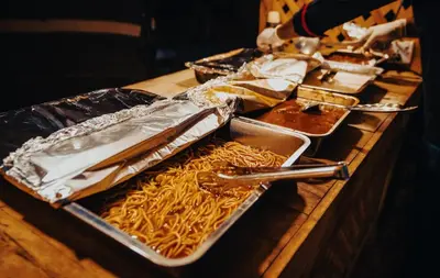 a table topped with trays of food on a table at Wadi Rum Desert Dunes Luxury Camp in Wadi Rum