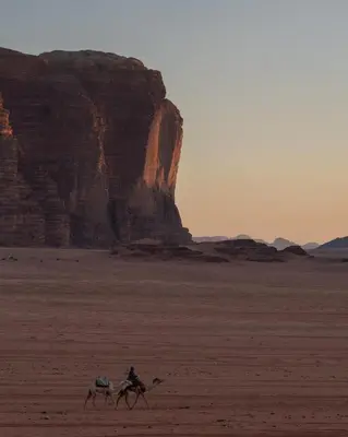 two people are riding horses in the desert at Wadi Rum Desert Dunes Luxury Camp in Wadi Rum