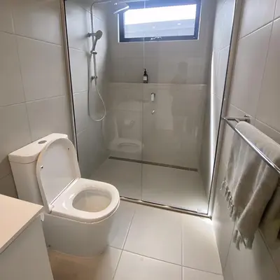 a white bathroom with a shower and a toilet at Charlotte luxury camp in Wadi Rum