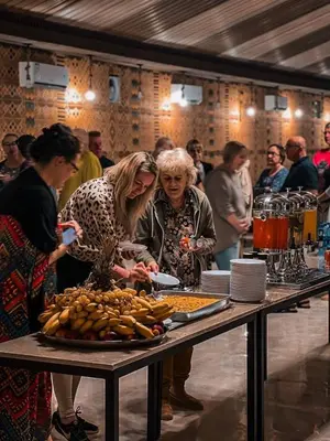 a group of people standing around a table with food at Charlotte luxury camp in Wadi Rum