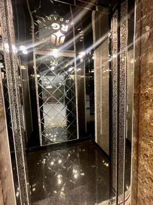 a reflection of a room with a mirror and some lights at رويال جروب اربد Royal Group Hotel in Irbid