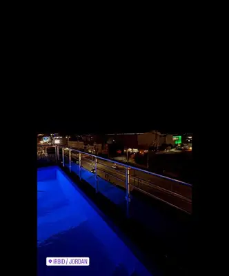 a view of a city at night with lights at رويال جروب اربد Royal Group Hotel in Irbid