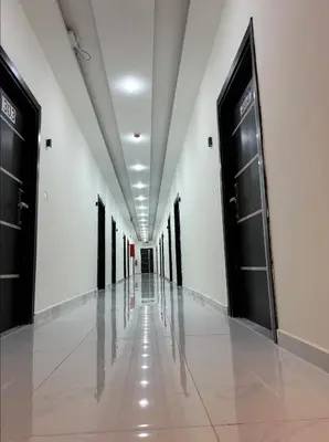 an empty hallway with black doors and white walls at رويال جروب اربد Royal Group Hotel in Irbid