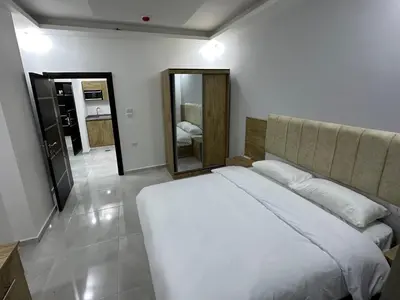 a bedroom with a white bed and a mirror at رويال جروب اربد Royal Group Hotel in Irbid
