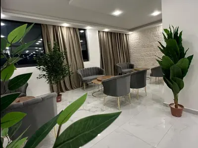 a waiting room with chairs and tables and plants at رويال جروب اربد Royal Group Hotel in Irbid