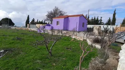 a purple house in a field with a fence at Jerash mountain studio chalet شاليه جبال جرش و عجلون in Jerash