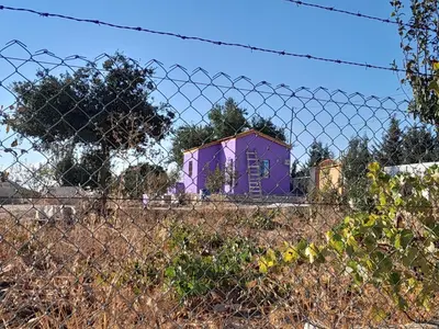 a purple house behind a barbed wire fence at Jerash mountain studio chalet شاليه جبال جرش و عجلون in Jerash