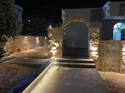 an entrance to a house at night with lights at Wadi Al-Nakhil Hostel in Al Khuraybah