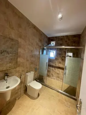 a bathroom with a toilet and a shower and a sink at Wadi Al-Nakhil Hostel in Al Khuraybah