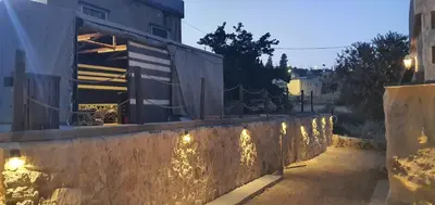 a stone wall with lights on a street at Wadi Al-Nakhil Hostel in Al Khuraybah
