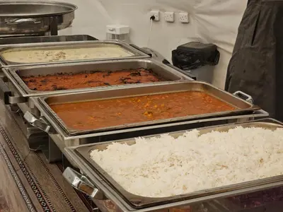 a group of trays of food with rice at MAXIMAS LUXURY Wadi Rum in Wadi Rum
