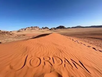 a desert with the word reunion written in the sand at Tamim Luxury wadi rum camp in Wadi Rum