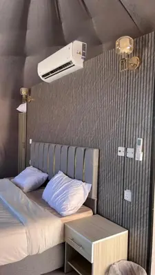 a bedroom with a bed and a air conditioner at SELEN RUM LUXURY CAMP & Jeep Tours in Wadi Rum