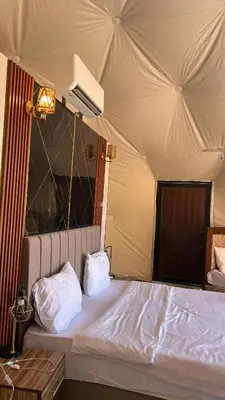 a bed with two pillows on it in a room at SELEN RUM LUXURY CAMP & Jeep Tours in Wadi Rum