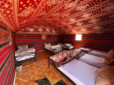 a room with two beds and a red ceiling at Wadi Rum Time in Wadi Rum