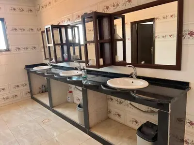 a bathroom with three sinks and two mirrors at Wadi Rum Time in Wadi Rum
