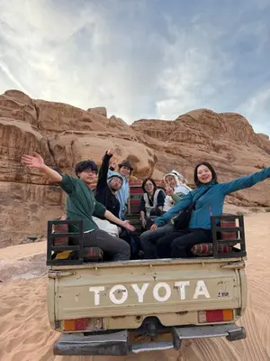 a group of people sitting in the back of a truck at Wadi Rum Time in Wadi Rum