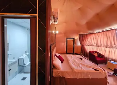 a small bedroom with a bed and a toilet at Amazing Wadi Rum Camp in Wadi Rum