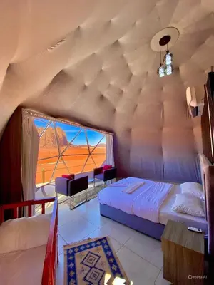 a bedroom with a bed and a large window at Amazing Wadi Rum Camp in Wadi Rum