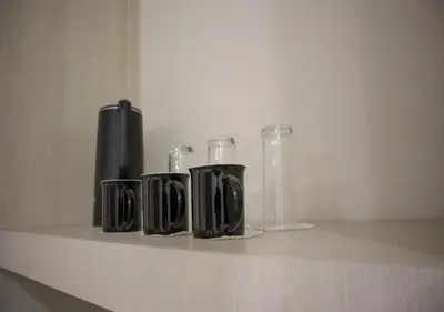 a shelf with three black glass containers on it at Amman Trail Hotel & Studios in Amman