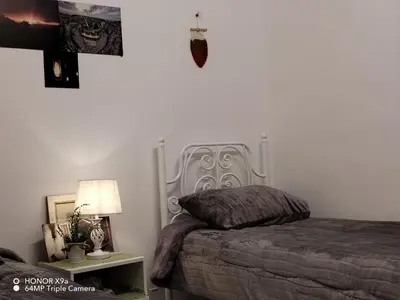 a bedroom with a bed and a table with a lamp at Seleucia DaR Umm Qais in Um Qeis
