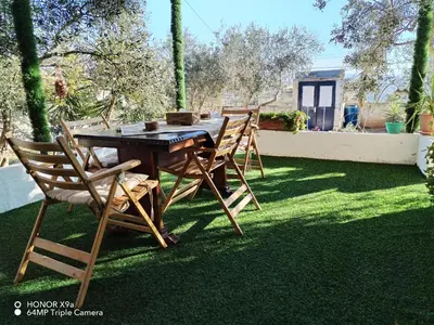 a wooden table and chairs on a lawn at Seleucia DaR Umm Qais in Um Qeis