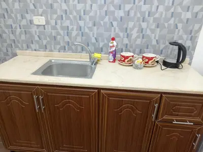 a kitchen counter with a sink and two cups at EMILE ALTWAL Hotel in Madaba